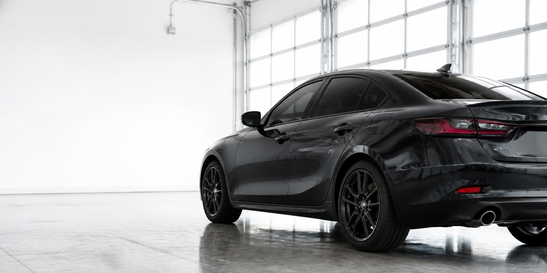 Graphite car with professionally tinted windows in a bright workshop